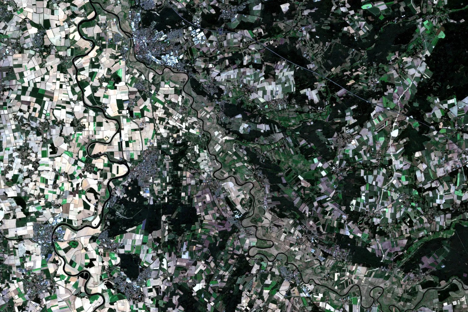 Sentinel-2 true-colour scene over farmland in Lower Saxony: a meandering river valley, a dense mosaic of harvested and still-green fields, patches of forest and scattered villages